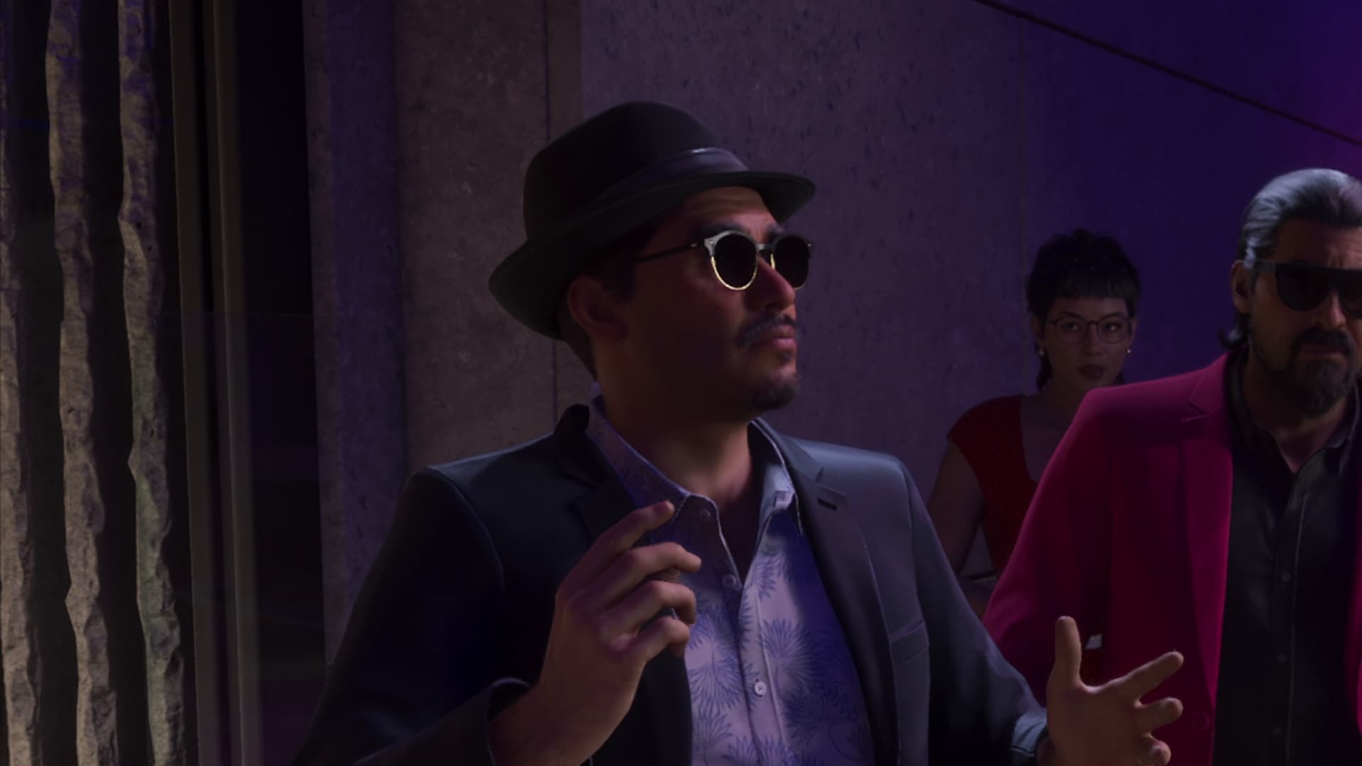Andres de Leon in a hat and glasses gestures at the Megamundo party entrance