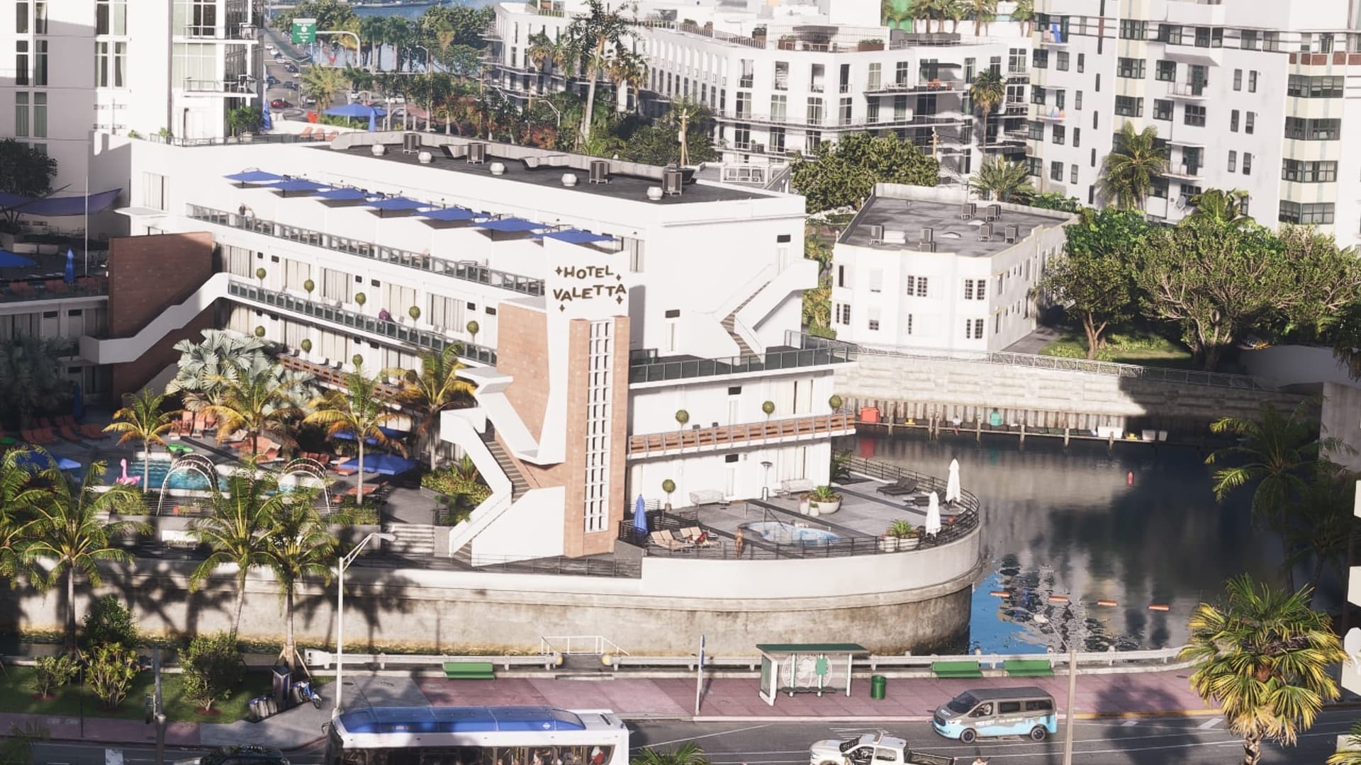 Low L-shaped hotel with a pool and round terrace over a canal