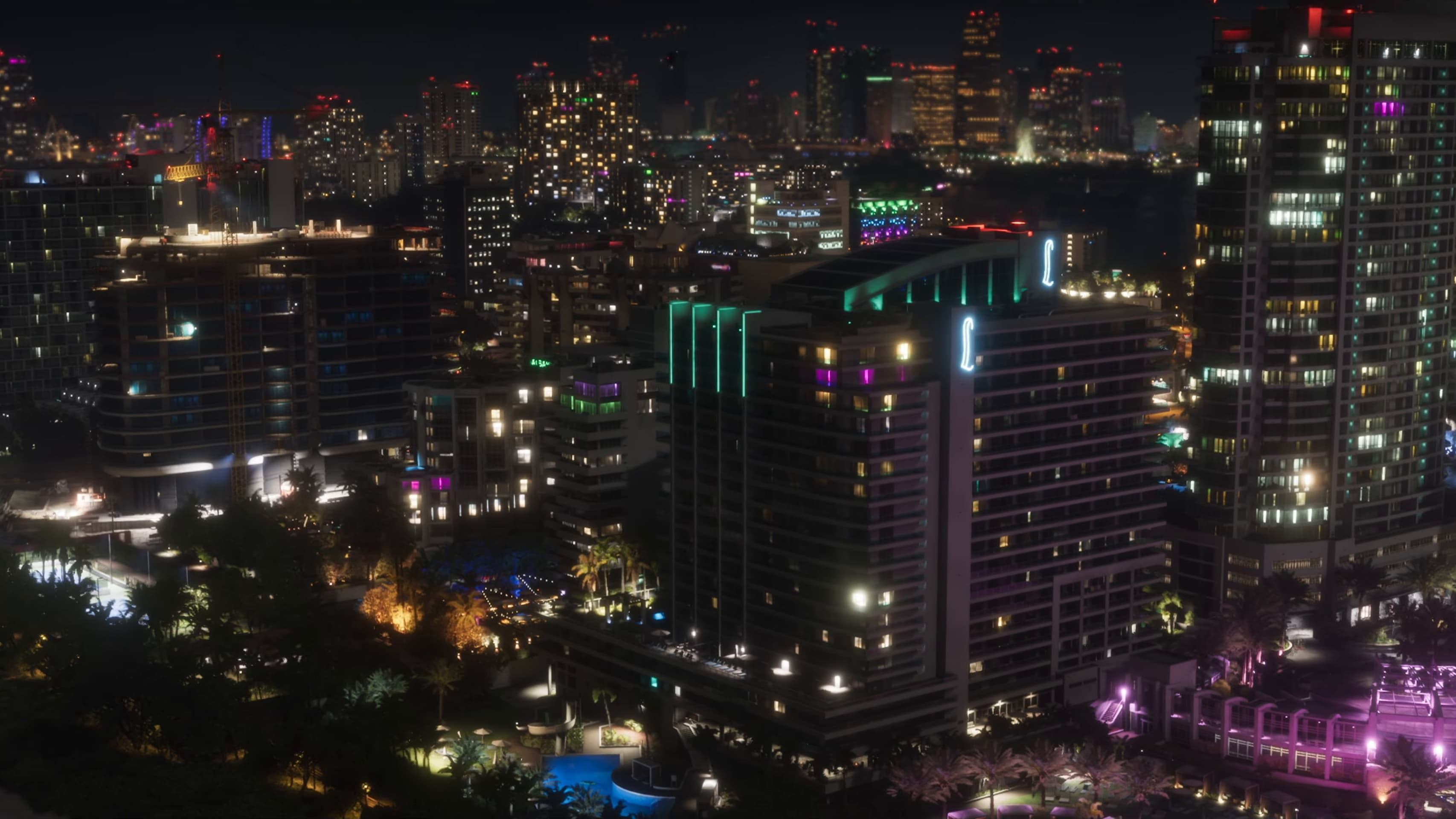 Lit hotel towers of Washington Beach at night with pools below