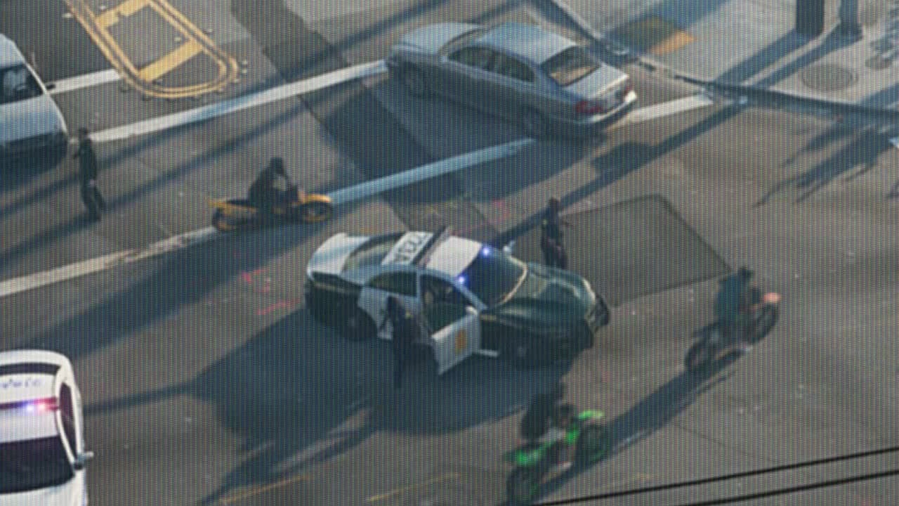 Green and white patrol car with its door open at a Vice City intersection, seen from a helicopter, in GTA VI Trailer 1